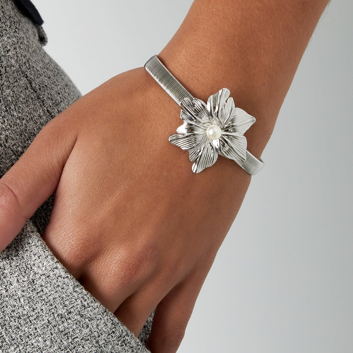 Brazalete de acero con flor y perla acabado oro
