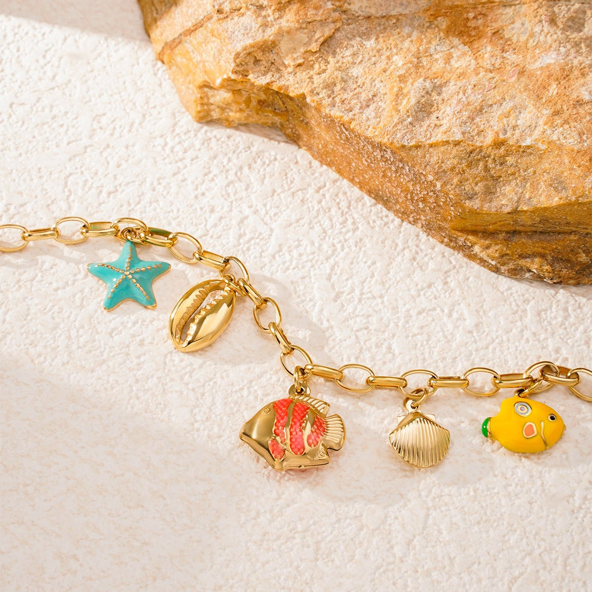 Pulsera acero de eslabones con dijes estrella, conchas y peces acabado oro - mbyou