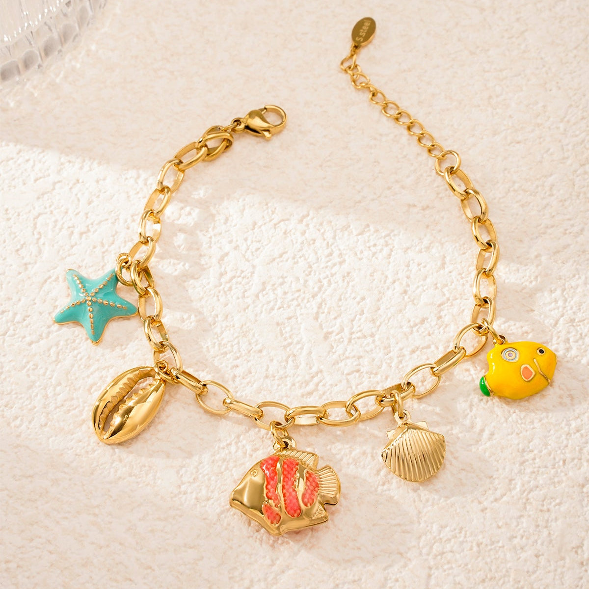 Pulsera acero de eslabones con dijes estrella, conchas y peces acabado oro - mbyou