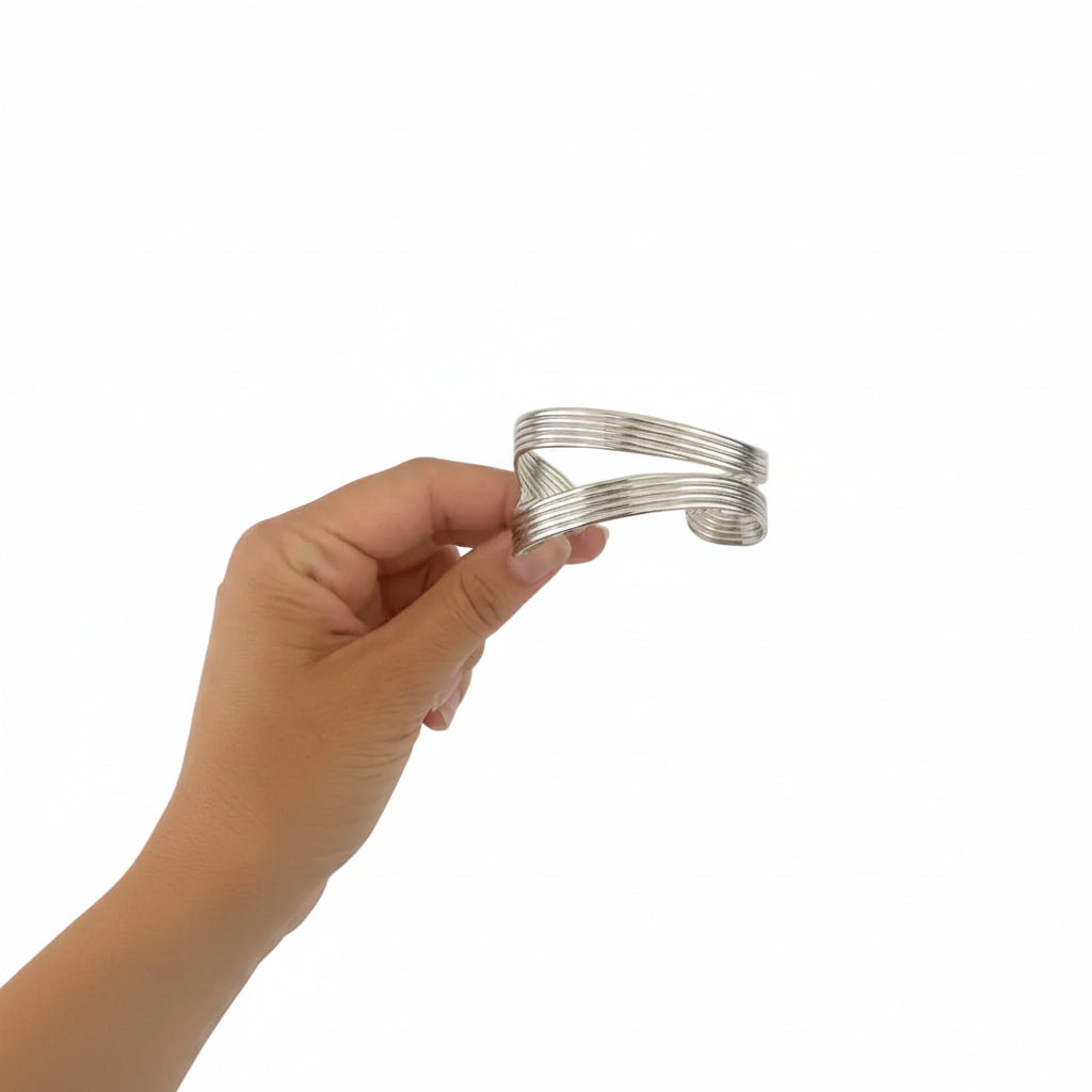Brazalete abierto de acero con un diseño a tiras ovaladas en varios acabados