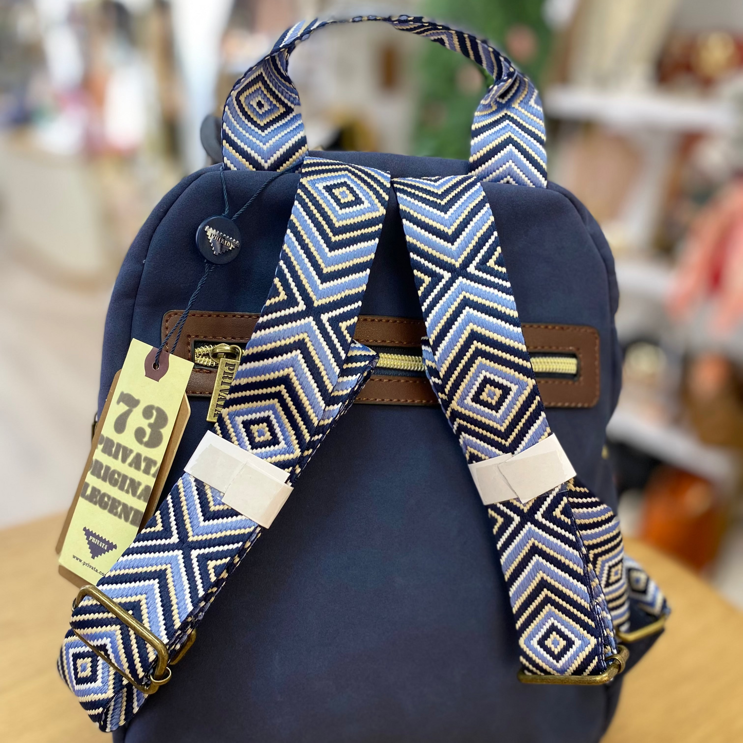 Mochila piel de melocotón con detalle de pompones de color marrón chocolate y azul marino -mbyou