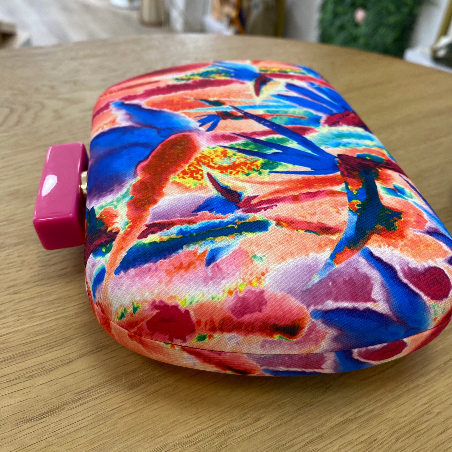 Bolso de mano fiesta tipo pochette con estampado abstracto en tonos rosa fucsia, naranjas y azules y cierre fucsia -mbyou