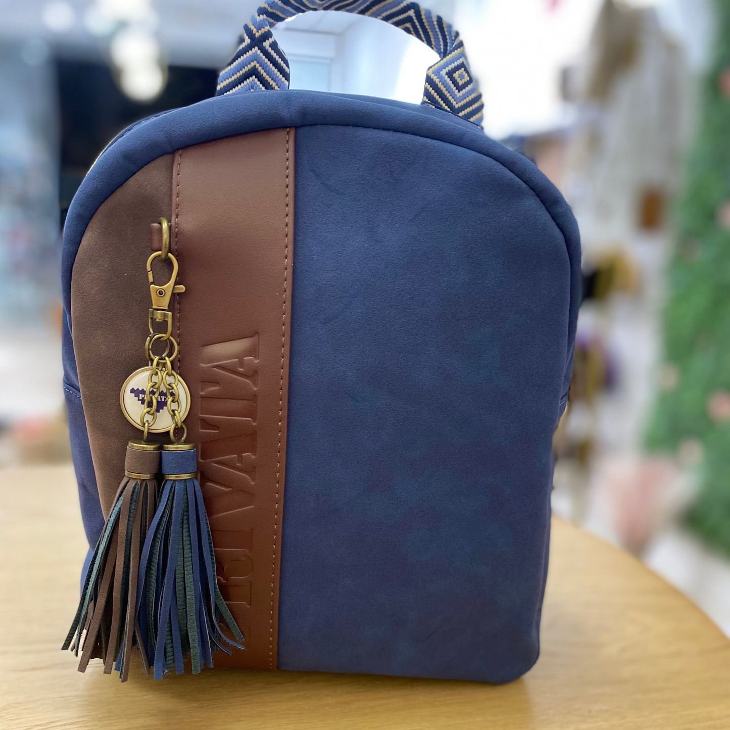Mochila piel de melocotón con detalle de pompones de color marrón chocolate y azul marino -mbyou