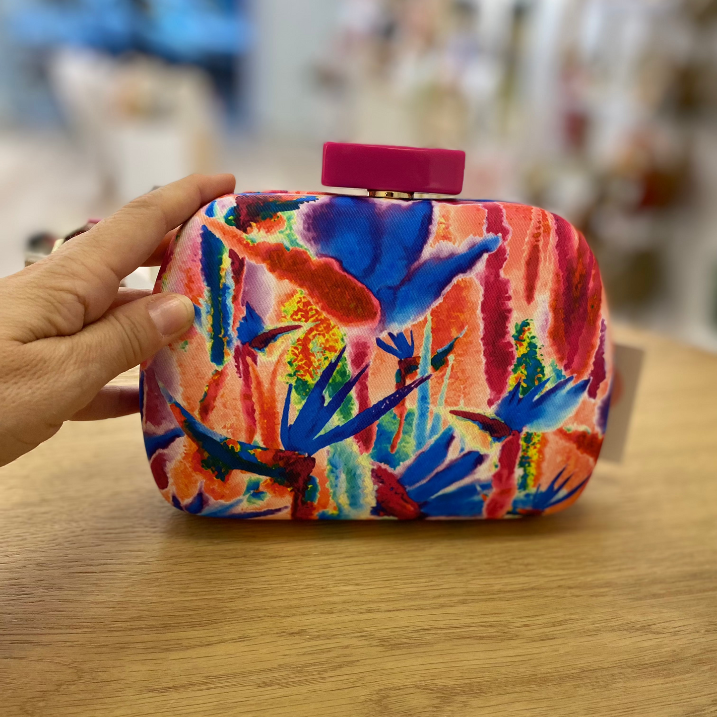 Bolso de mano fiesta tipo pochette con estampado abstracto en tonos rosa fucsia, naranjas y azules y cierre fucsia -mbyou