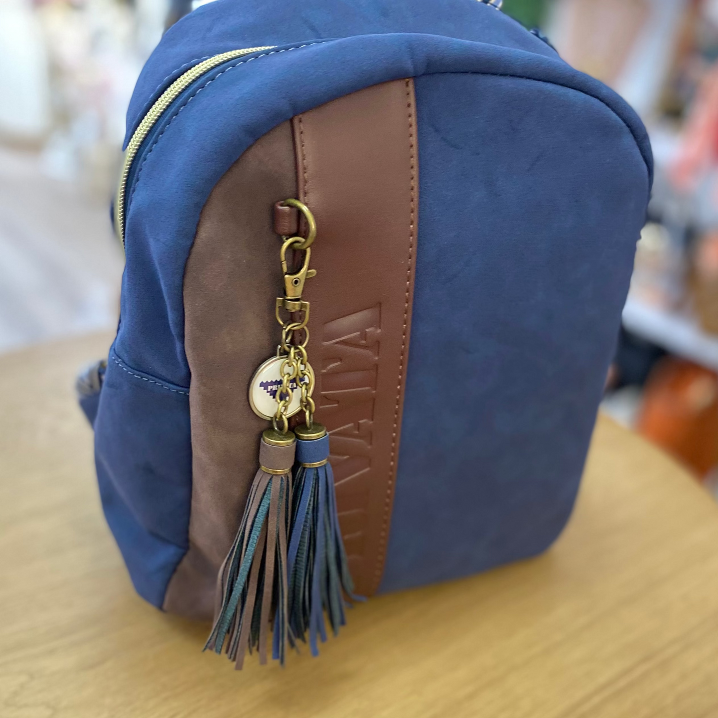 Mochila piel de melocotón con detalle de pompones de color marrón chocolate y azul marino -mbyou