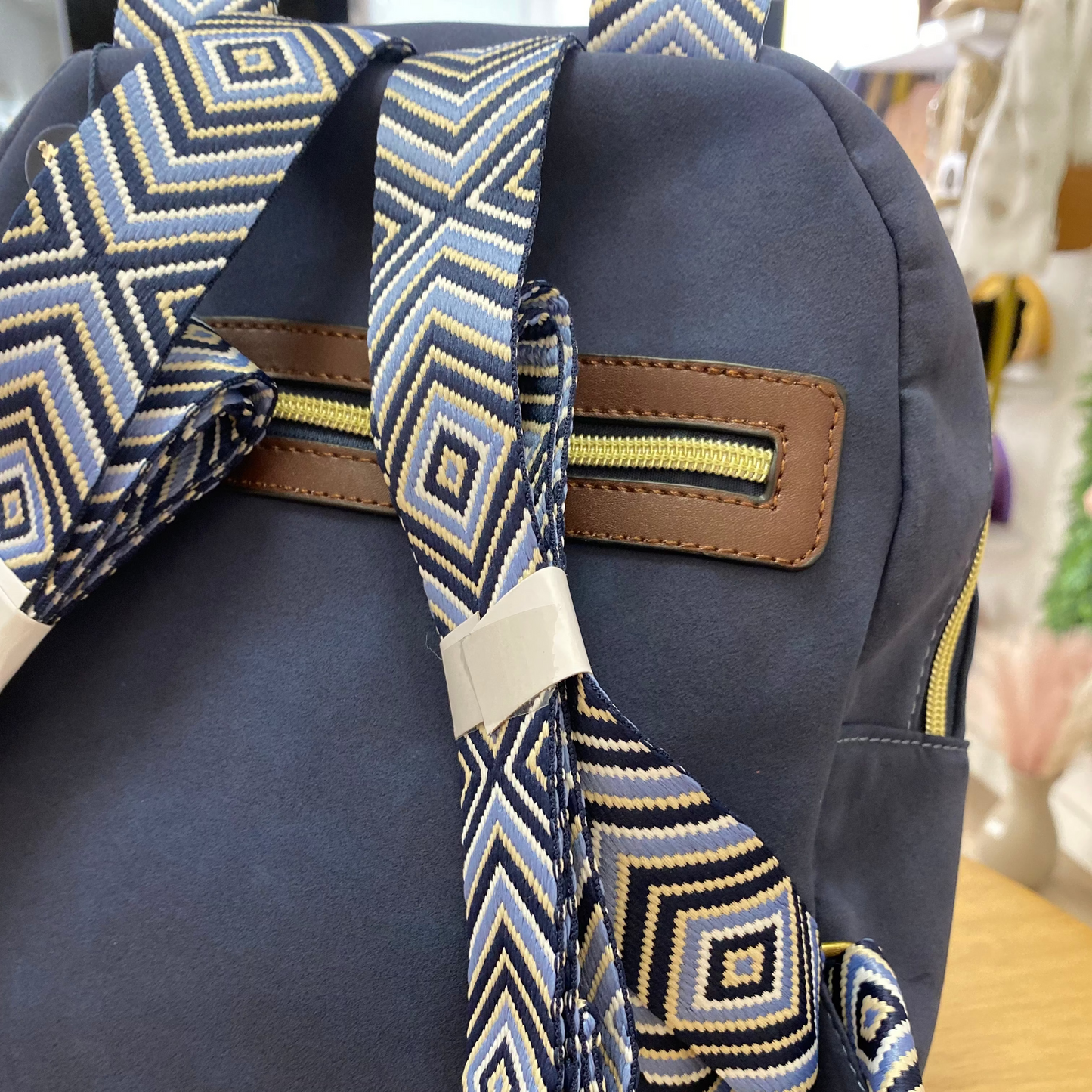 Mochila piel de melocotón con detalle de pompones de color marrón chocolate y azul marino -mbyou