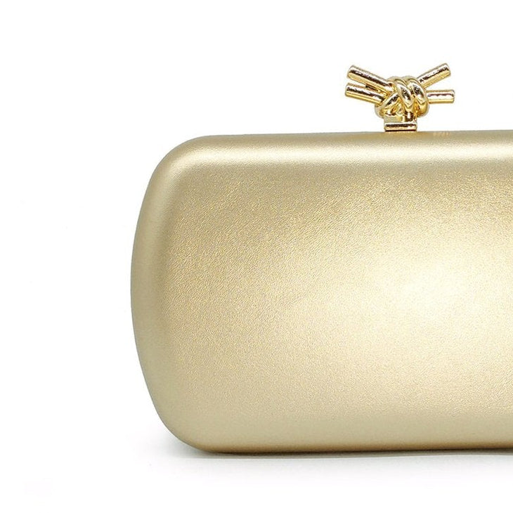 Bolso de mano tipo clutch en forma rectangular con cierre en forma de nudo en color dorado mate - mbyou
