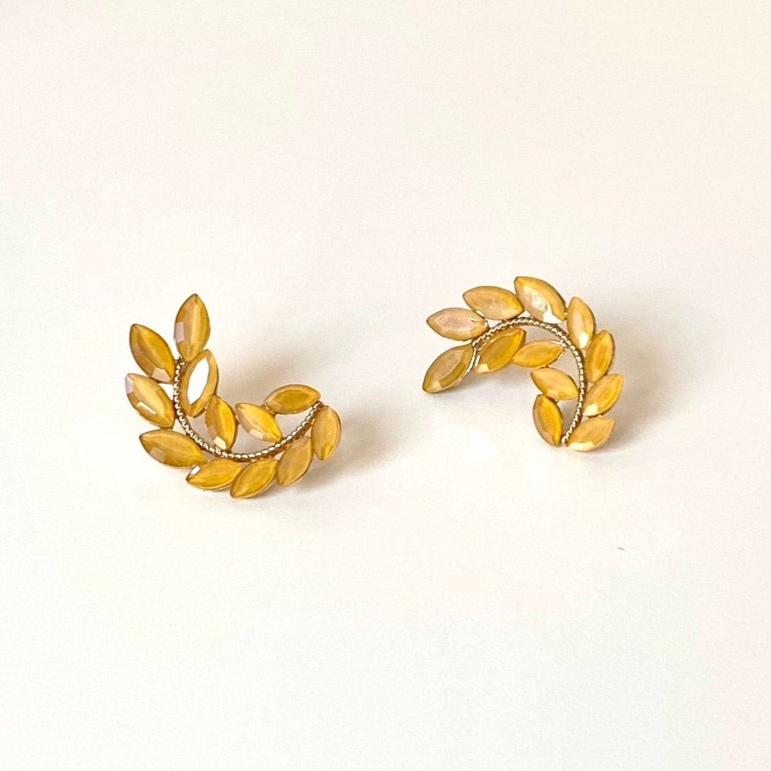 Pendientes largos forma laurel con cristales mostaza y acabado oro