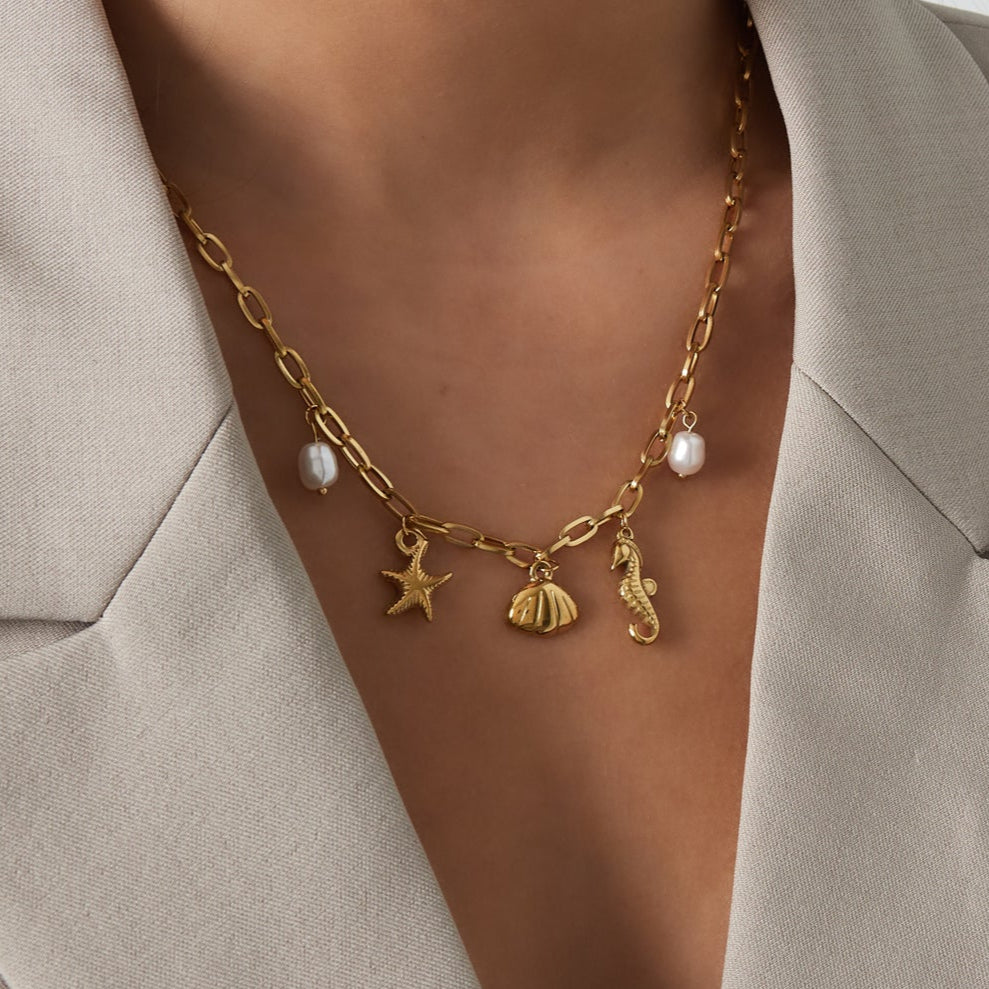 Collar acero de eslabones con dijes estrella marina, conchas, perlas y caballito de mar acabado oro - mbyou