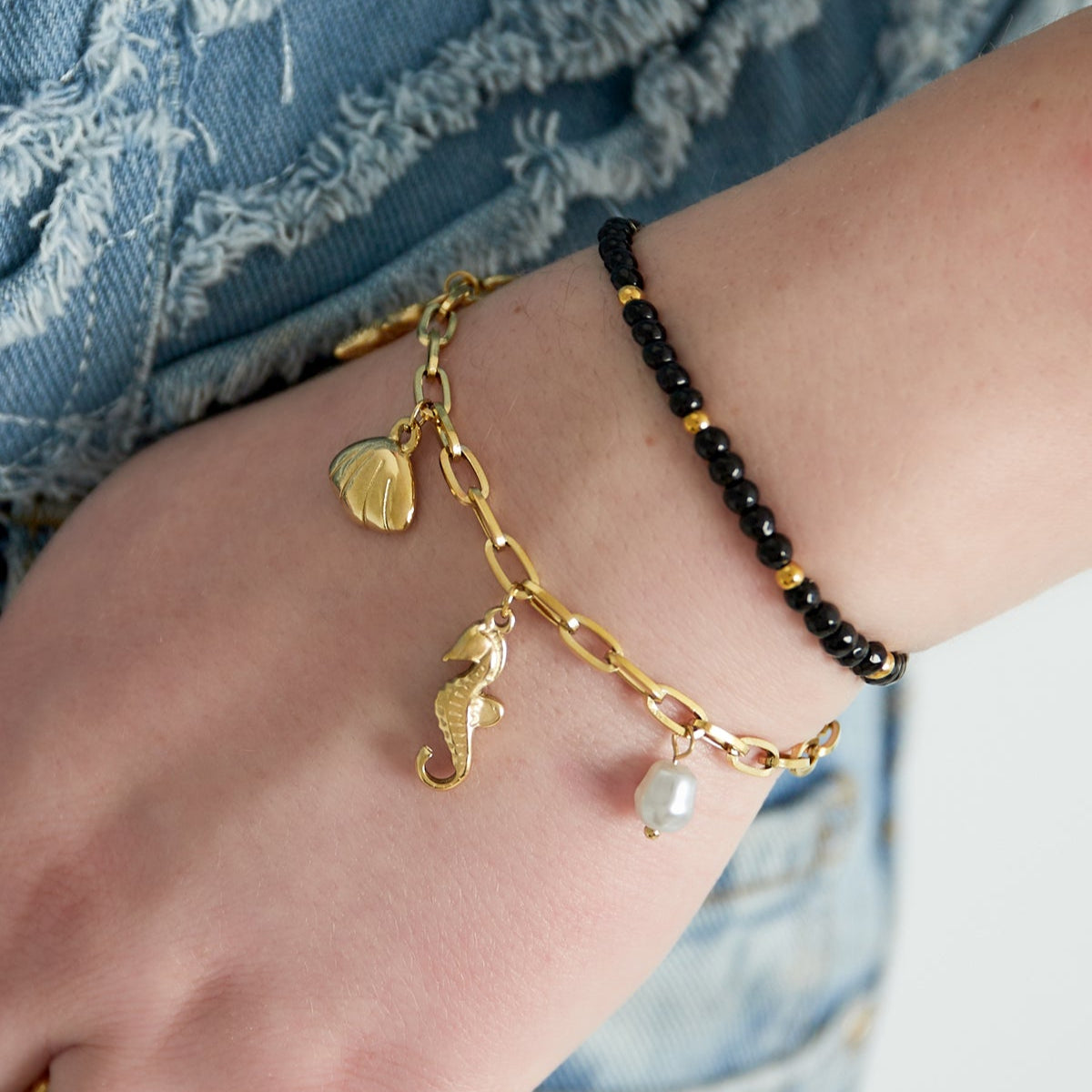 Pulsera acero de eslabones con dijes estrella marina, conchas y perlas acabado oro - mbyou