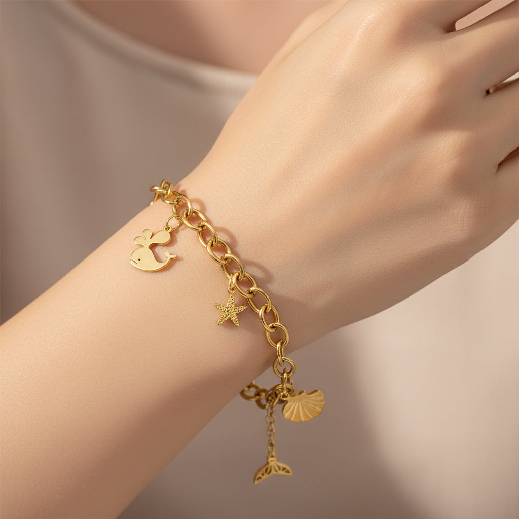 Pulsera de acero con cadena de eslabones y dijes marinos en acabado oro