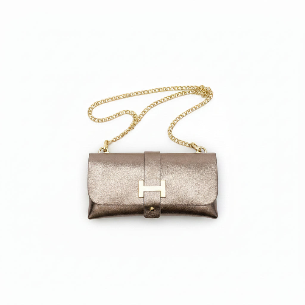 Bolso fiesta de mano tipo sobre en color cobre con una hebilla dorada