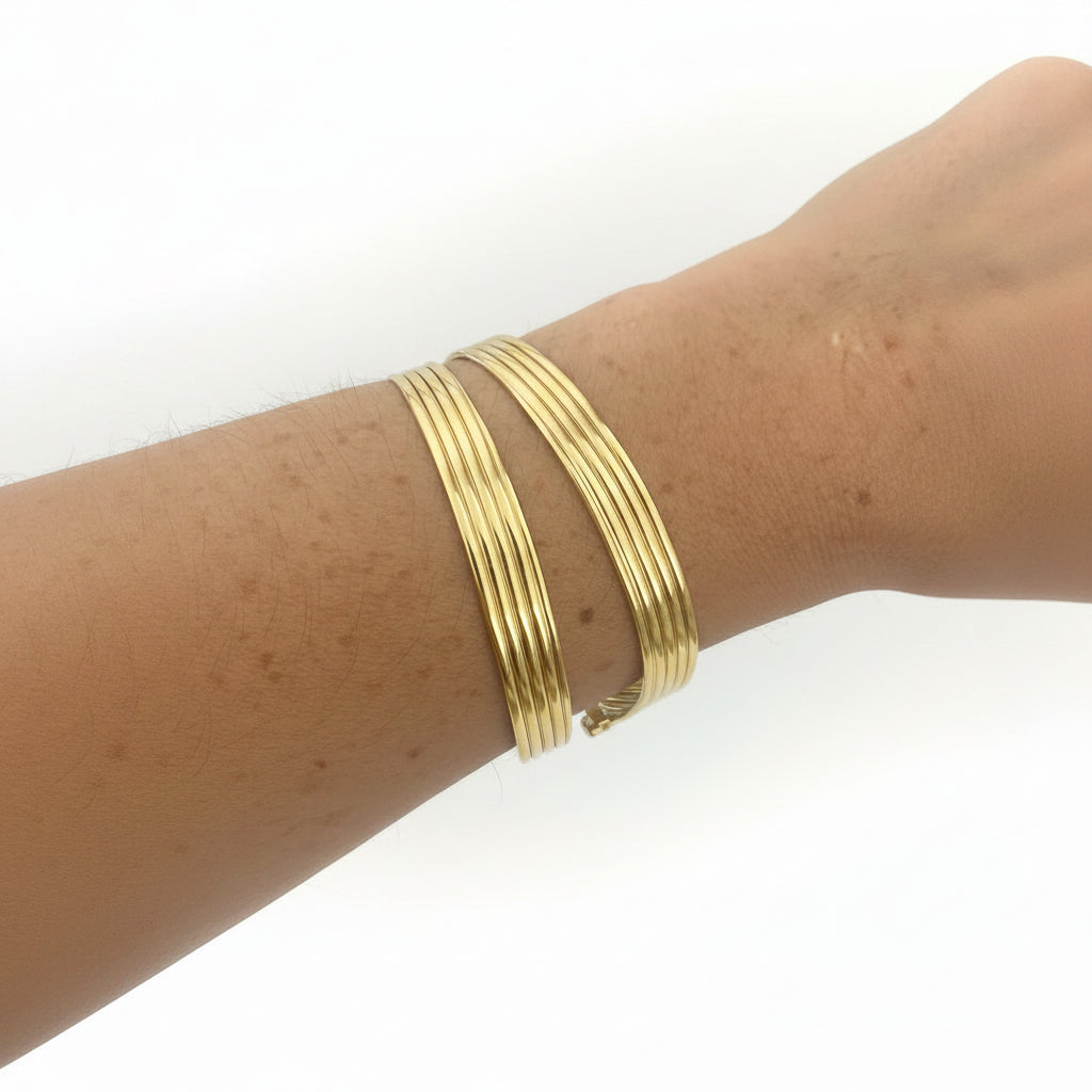 Brazalete abierto de acero con un diseño a tiras ovaladas en varios acabados