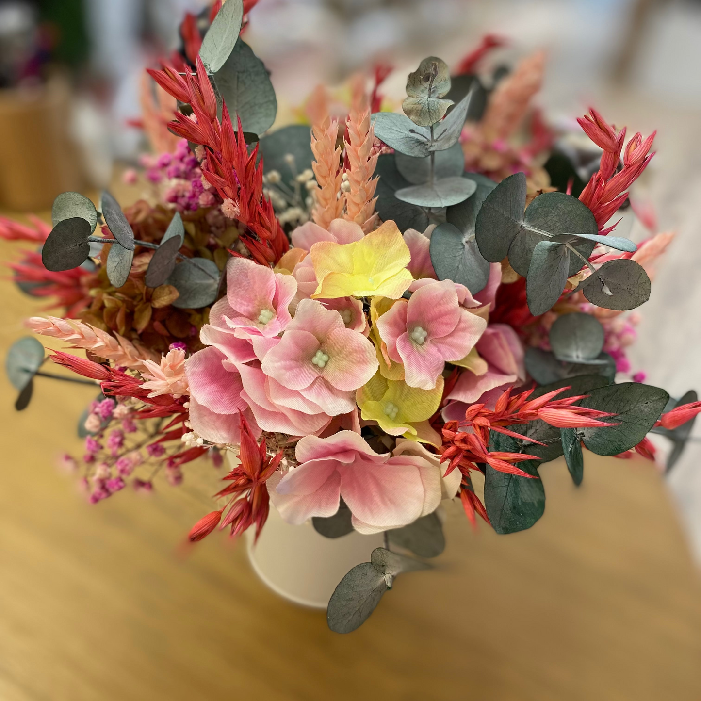 Centro de flores con hortensias y eucalipto preservado y artificial