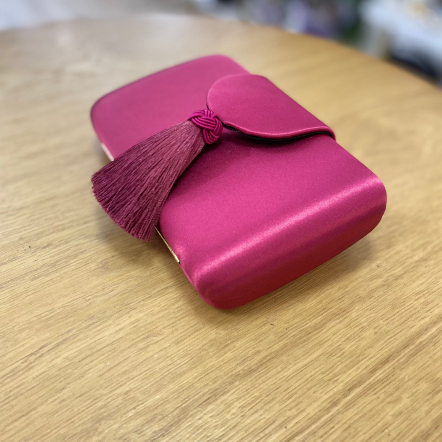 Bolso clutch buganvilla con solapa y borla