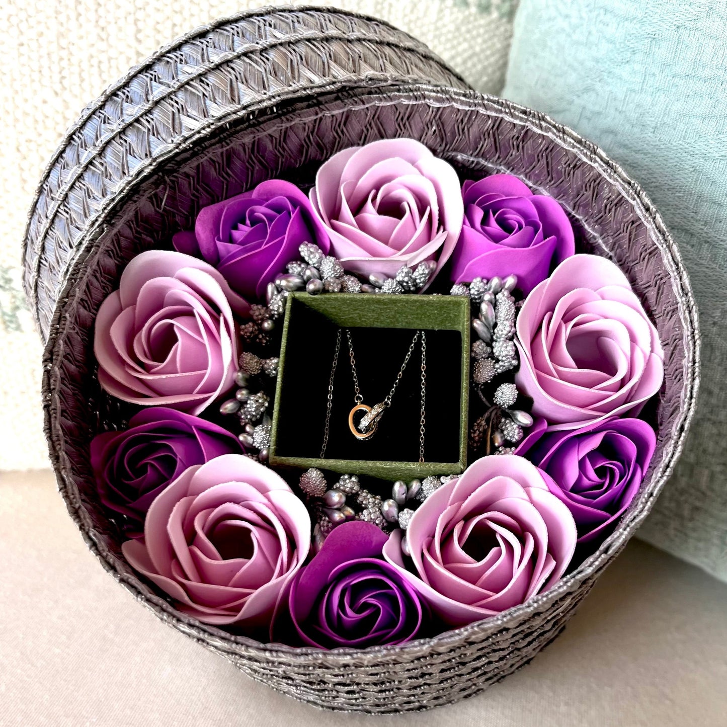 Cofre joyero regalo gris pequeño con flores de jabón moradas y collar de plata anillos enlazados