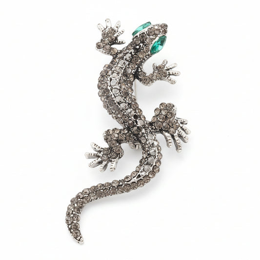 Broche en forma de lagartija en color gris, ojos verdes y acabado plata