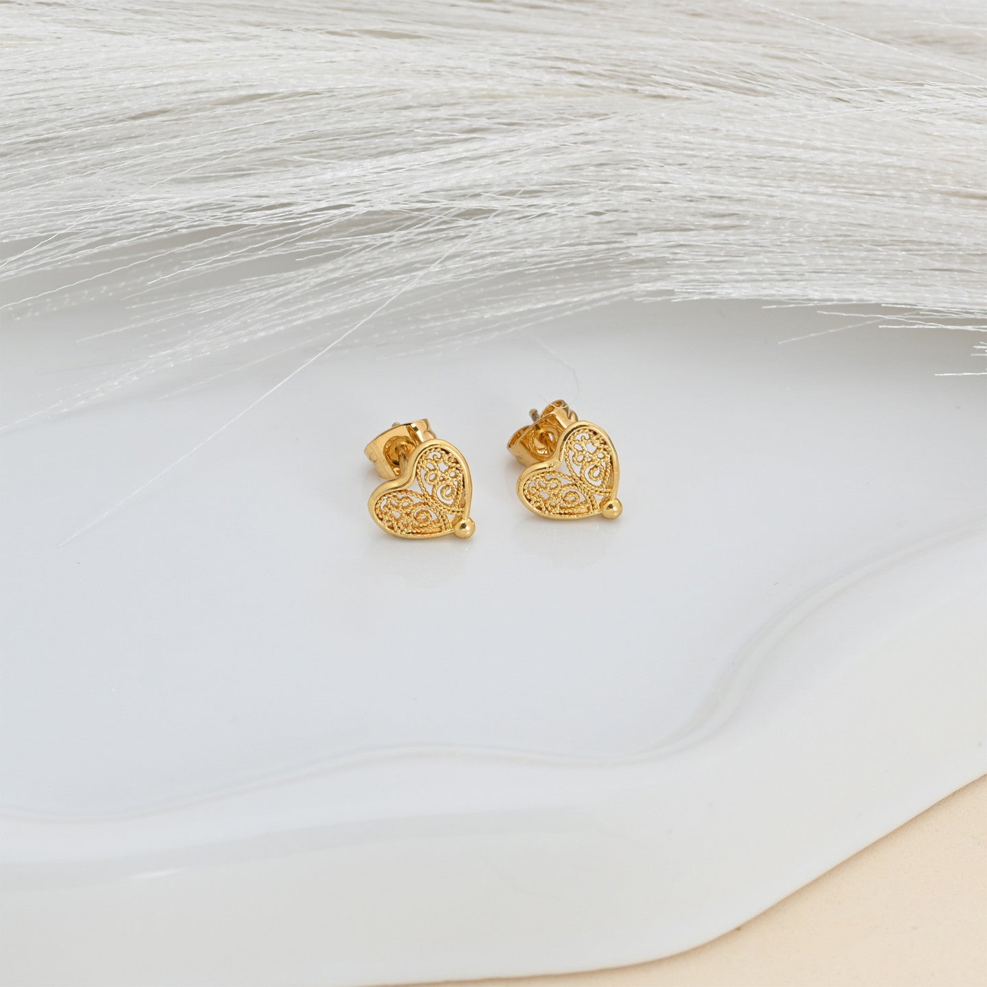 Pendientes pequeños de corazón con diseño de filigrana.