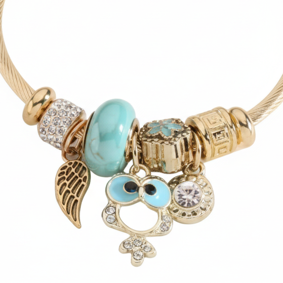 Pulsera abierta con dijes diferentes en turquesa y acabado oro